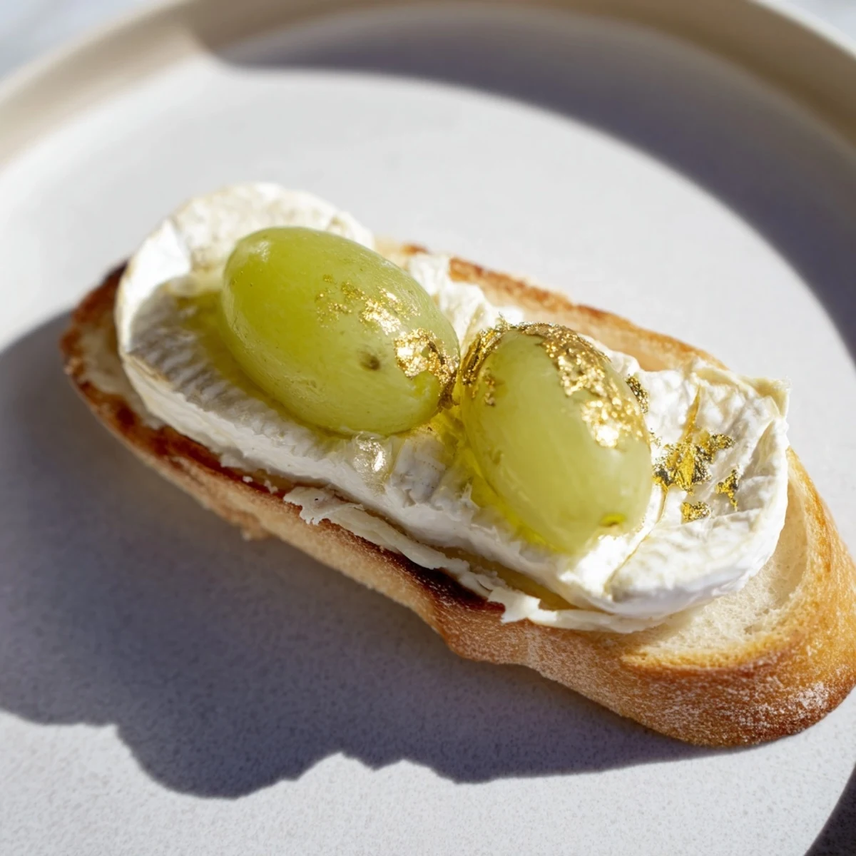 A platter of Sparkling Champagne Toast, golden-dusted, with grapes bursting from creamy cheese for elegant appetizers.