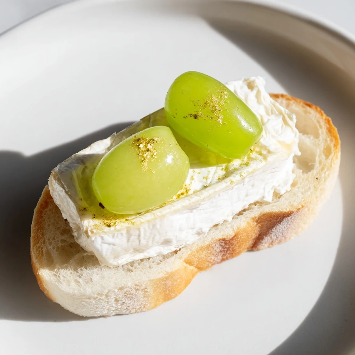 Close-up of Sparkling Champagne Toast, showcasing soaked grapes and gold glitter atop toasted bread, a festive bite.