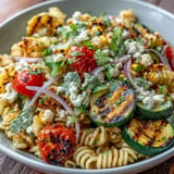 Pasta-Salat mit rauchiger Zucchini, süßem Mais und cremigem Cotija-Käse, verfeinert mit Zitronendressing.  
