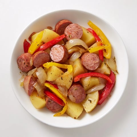 Saftige, goldbraune 1-Pot Kielbasa and Potato Bake, dampfend heiß serviert, mit frischen Kräutern.