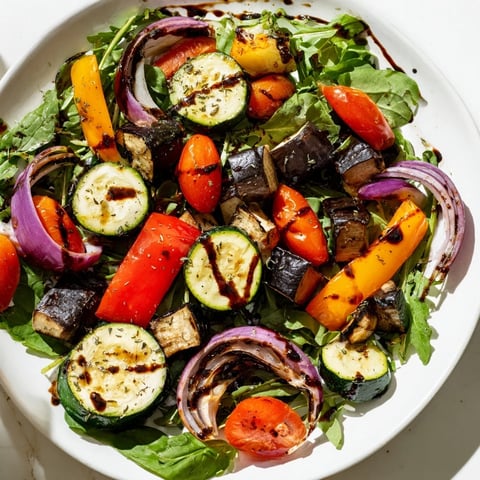 Warm bowls of Roasted Vegetable Salad showcase colorful roasted veggies and fresh greens.