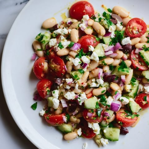 Creamy white bean salad, bursting with colorful tomatoes and herbs, a perfect Mediterranean side.