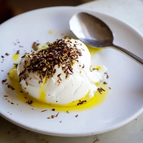 Creamy Levantine labneh cheese, drizzled with olive oil, ready for warm pita bread and a delicious spread.