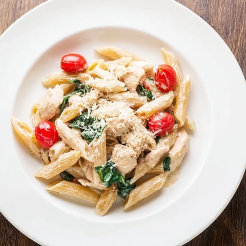 Hier siehst du die Greek Yogurt Chicken Pasta mit saftigem Hähnchen, Penne und frischen Spinatblättern auf dem Teller.