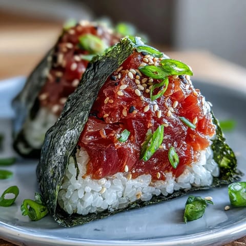 2. Leckere Spicy Tuna Onigiri mit saftigem Thunfisch-Füllung, leicht scharf gewürzt und in knusprige Nori-Blätter gewickelt.  