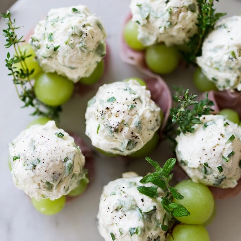 Vibrant image of a Mistletoe Kissing Ball, showcasing grapes, cheese balls, and aromatic herbs for holidays.