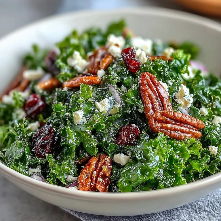 Saftiger, warm servierter Kale Salad mit Maple Mustard Dressing, Crunch von Nüssen und rosafarbenen Cranberries.