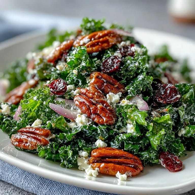 Warm Kale Salad mit Maple Mustard Dressing, gerösteten Walnüssen, Cranberries und roten Zwiebeln auf rustikalem Holztisch.