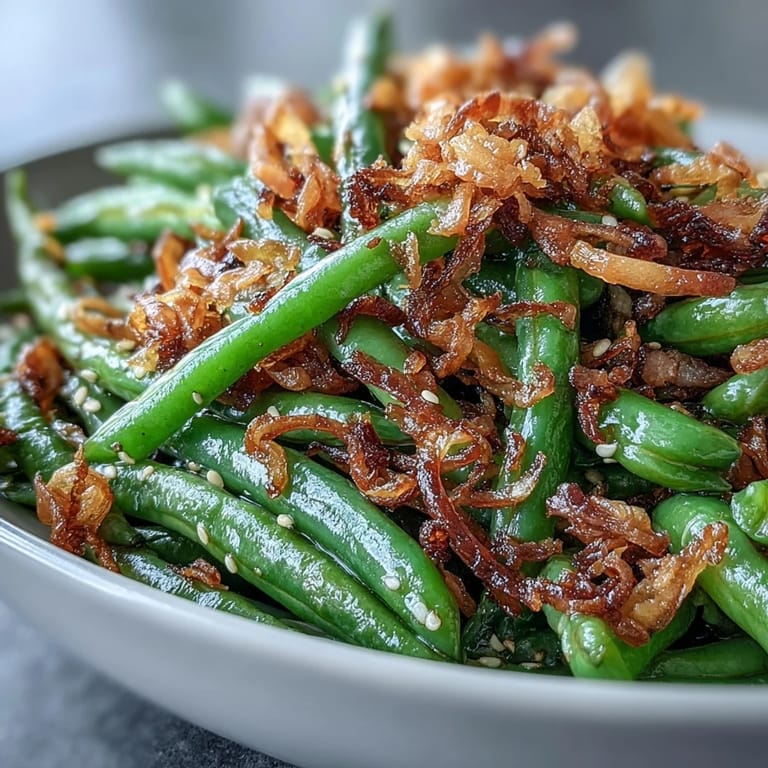 Duftende grüne Bohnen sautiert mit Knoblauch, Sesam und knusprigen Zwiebeln – perfekt als Beilage.