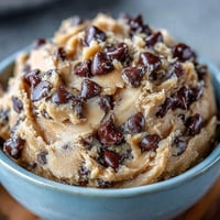 Proteinreicher Keksteig mit Schokoladenstückchen in einer Schüssel, bereit zum Naschen oder als Post-Workout-Snack.