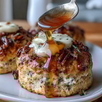 Zarte, goldene Scones mit Löwenzahnblüten und Honig, warm serviert mit reichhaltiger Clotted Cream—perfekt für ein Frühlingsbrunch.